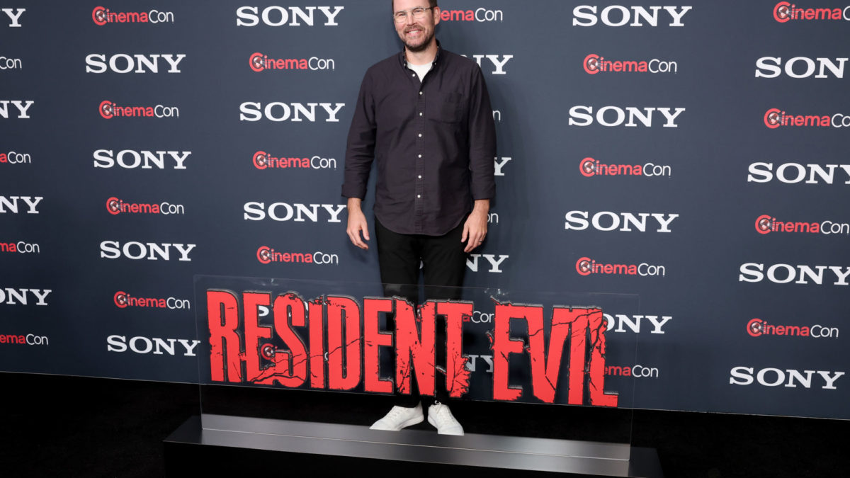 Zach Cregger poses on the red carpet at CinemaCon 2026, standing next to a bold 'RESIDENT EVIL' sign, with a backdrop featuring the Sony Pictures logo.