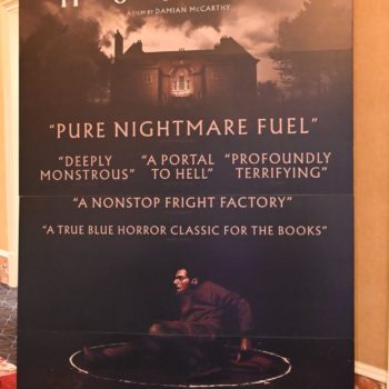 A promotional poster for the film 'Hokum' featuring Adam Scott. The design includes dark, moody imagery of a house and several quotes describing it as 'pure nightmare fuel' and 'a portal to hell,' with a tagline emphasizing its horror theme.