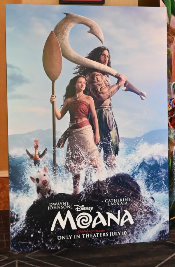 A promotional poster for Disney's 'Moana' featuring the characters Moana and Maui standing in ocean waves, holding a paddle and a hook. The poster includes the movie title and release information.