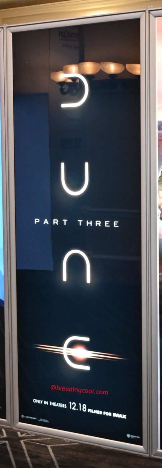 A promotional display for 'Dune: Part Three' features the film's title in large, illuminated letters against a dark background. The display includes details about the release date and indicates the film is filmed for IMAX.