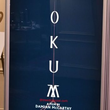 A promotional banner for the film 'Hokum,' featuring the name 'Adam Scott' prominently at the top, with a dark, atmospheric illustration of a house beneath a stormy sky. The tagline 'Only in theaters 5.1' and the producer 'Neon' are included at the bottom.