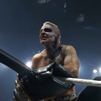 Darby Allin, a professional wrestler with distinctive face paint and tattoos, celebrates with the AEW Championship belt in hand, standing near the ring ropes under bright arena lights.