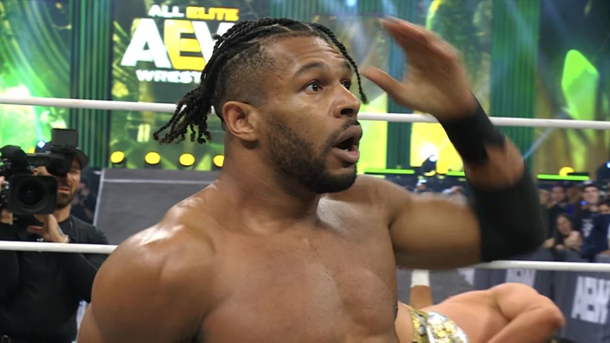 A shocked wrestler, Kevin Knight, stands in the ring with an expression of surprise, celebrating his unexpected victory. The AEW logo is visible in the background, emphasizing the event's context.