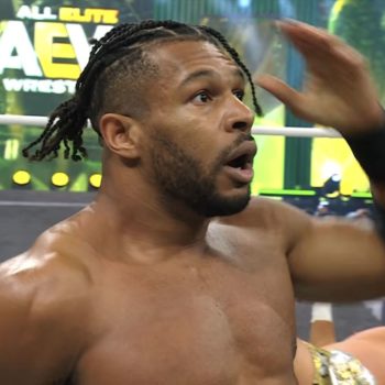 A shocked wrestler, Kevin Knight, stands in the ring with an expression of surprise, celebrating his unexpected victory. The AEW logo is visible in the background, emphasizing the event's context.