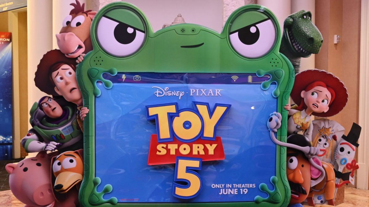 A colorful standee promoting "Toy Story 5," featuring the movie's logo and popular characters like Woody, Buzz Lightyear, and Jessie, set against a vibrant background. The standee announces the film's release date of June 19.