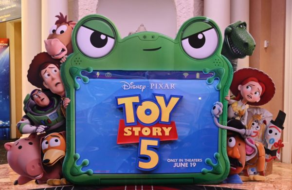 A colorful standee promoting "Toy Story 5," featuring the movie's logo and popular characters like Woody, Buzz Lightyear, and Jessie, set against a vibrant background. The standee announces the film's release date of June 19.